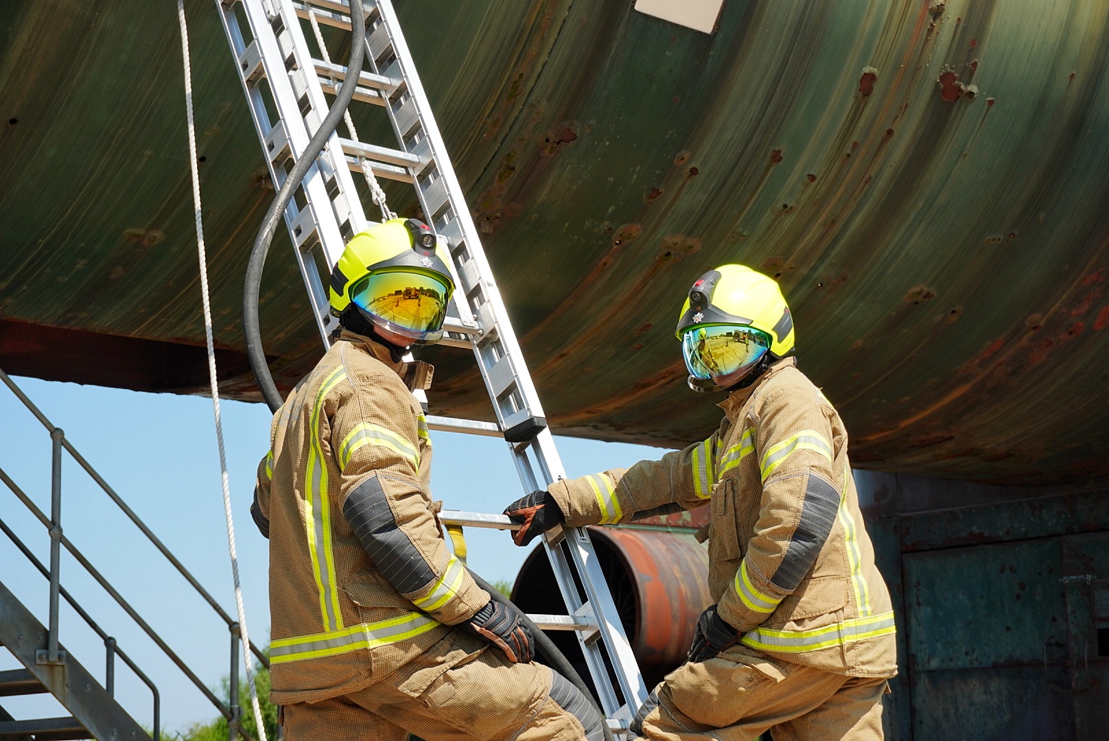 Two firefighters foot a 9m ladder against the simulated aircraft fuselage during the combination drill.