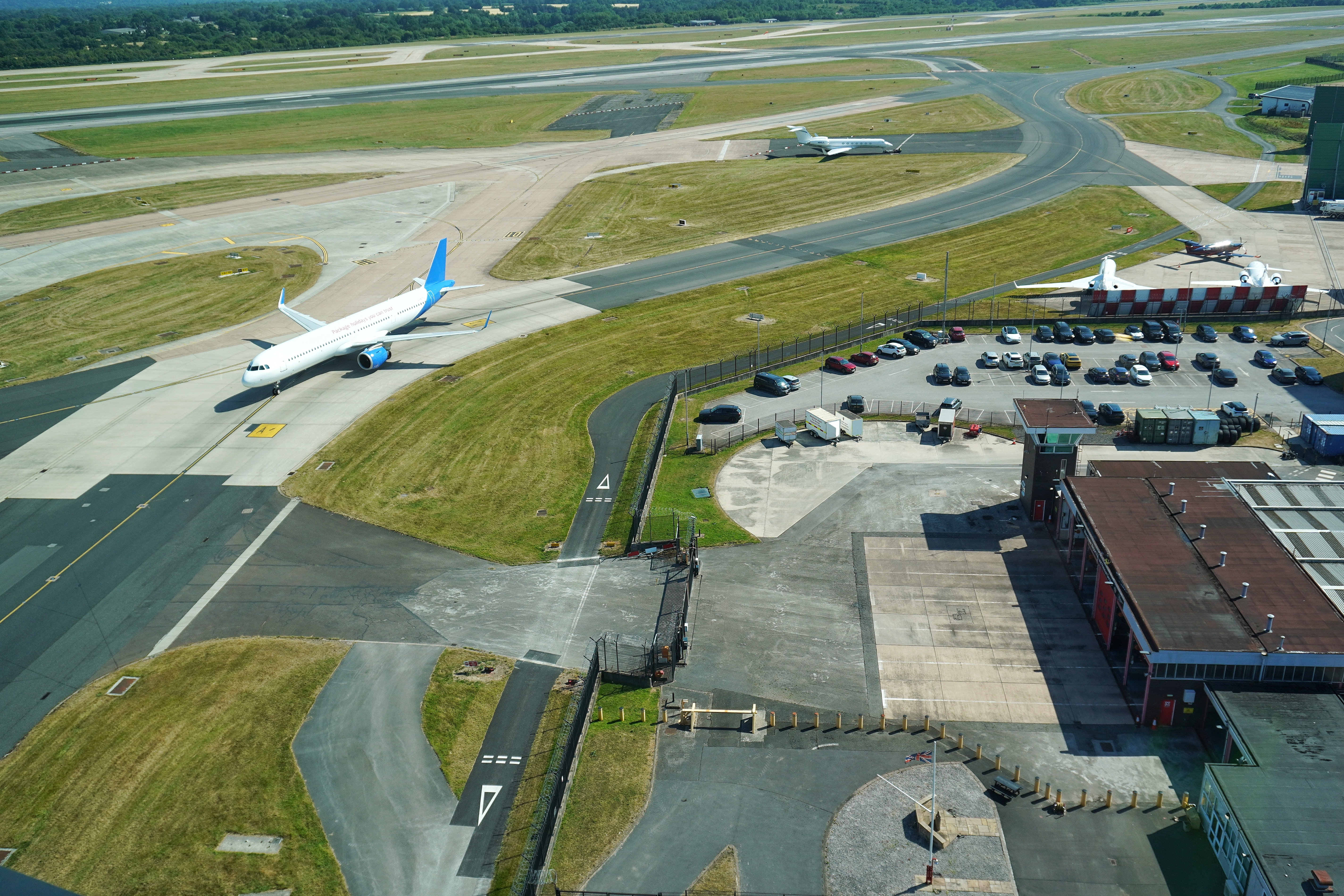 The view from the Watch Room over the Manchester Airport airfield — aircraft taxi past the fire station as normal airport life continues.