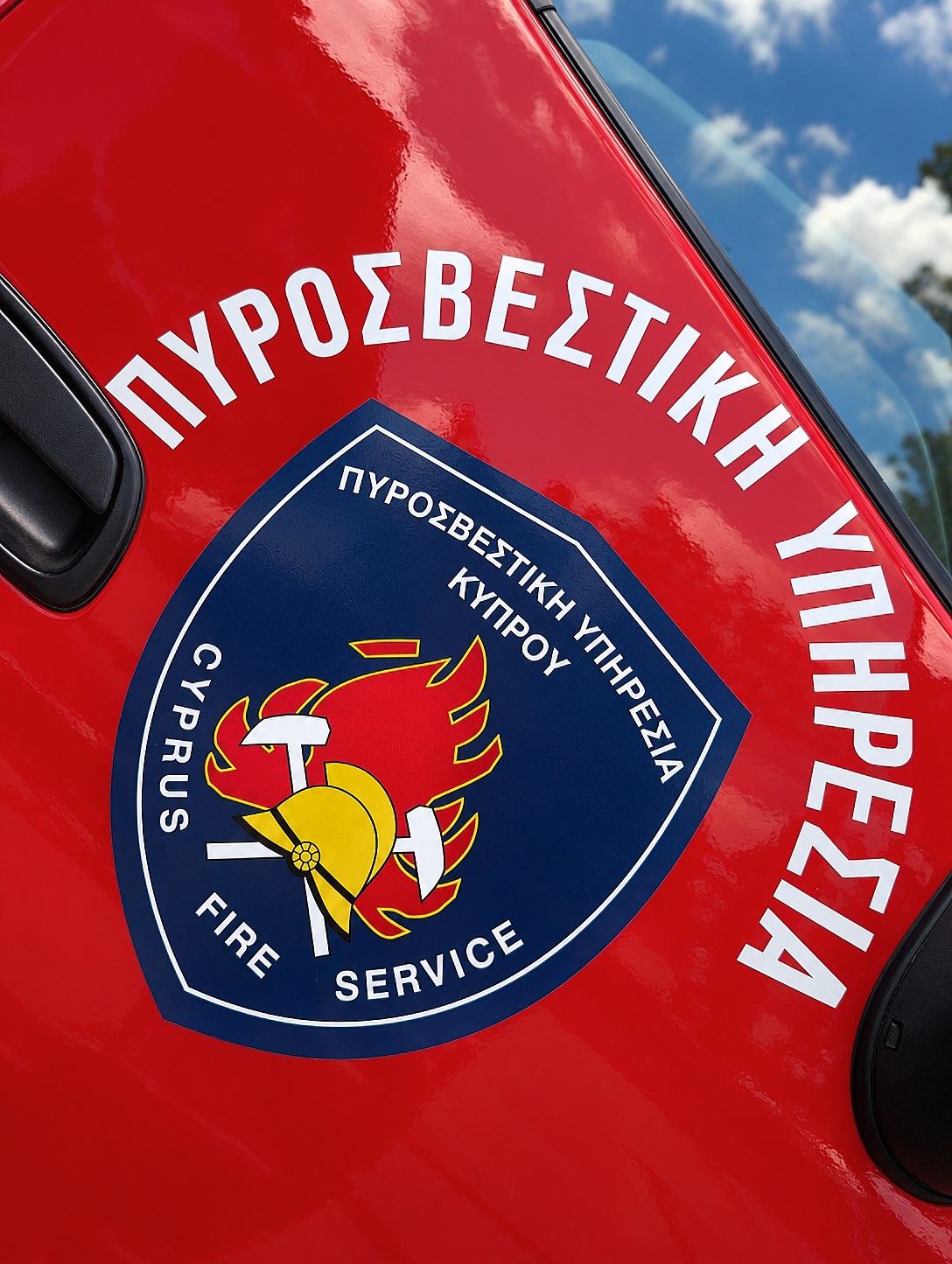 The Cyprus Fire Service crest — helmet, crossed axes and flame.