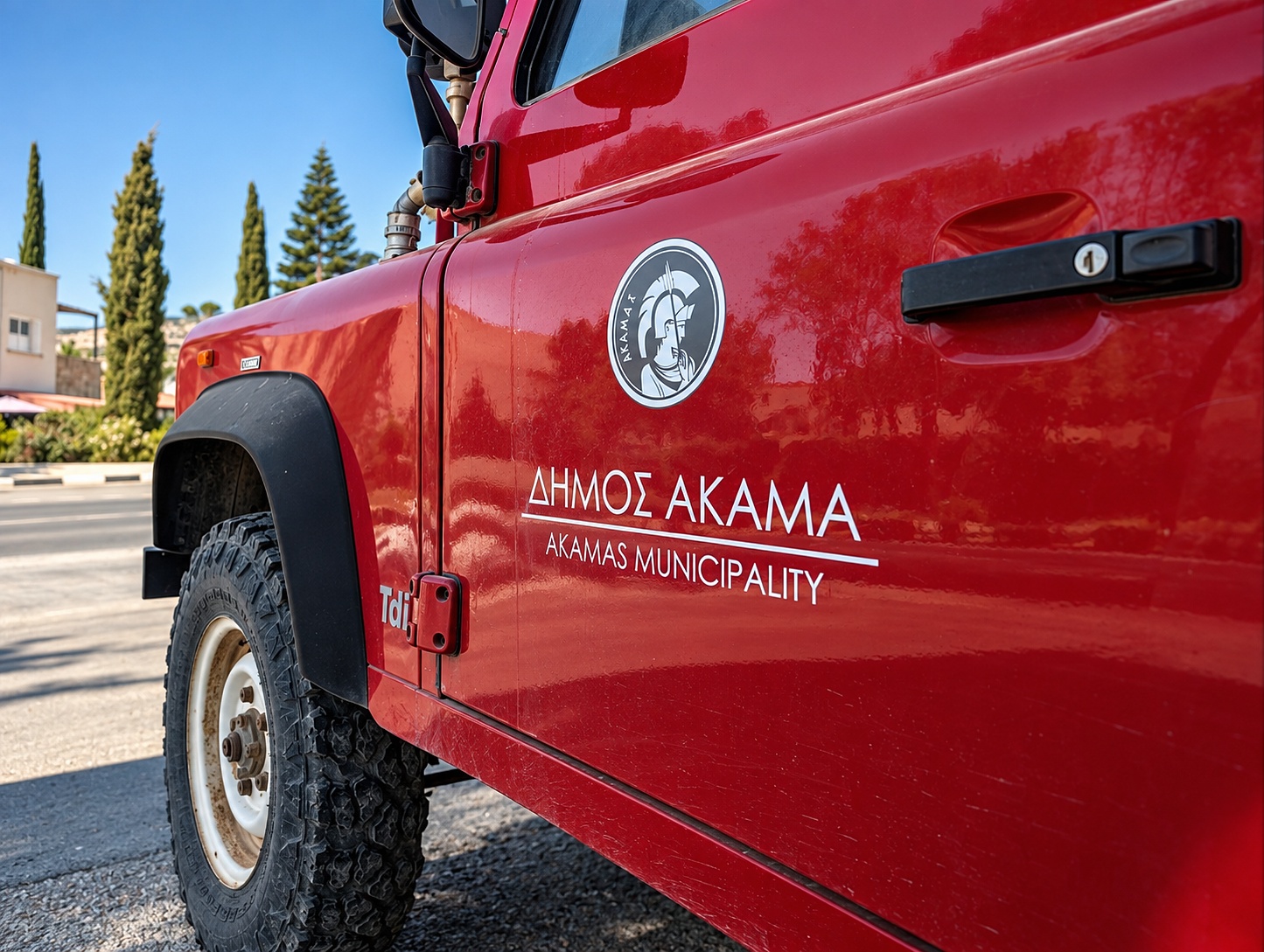 Akamas Municipality branding on the Defender door — ΔΗΜΟΣ ΑΚΑΜΑ, the local municipal fire cover.