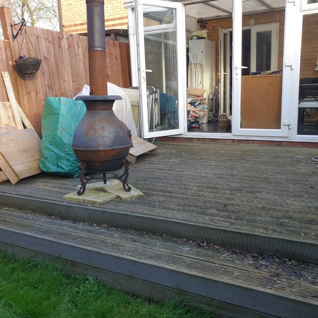 Weathered deck with an old fire pit before renovation