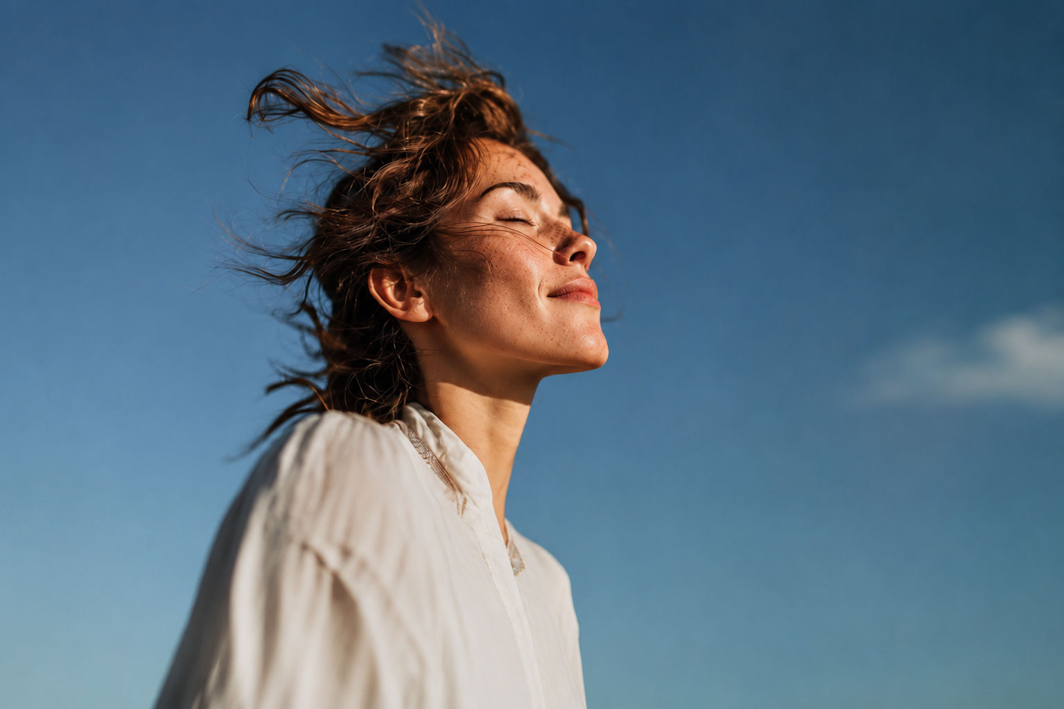 Mujer mirando hacia arriba con tranquilidad, cielo azul