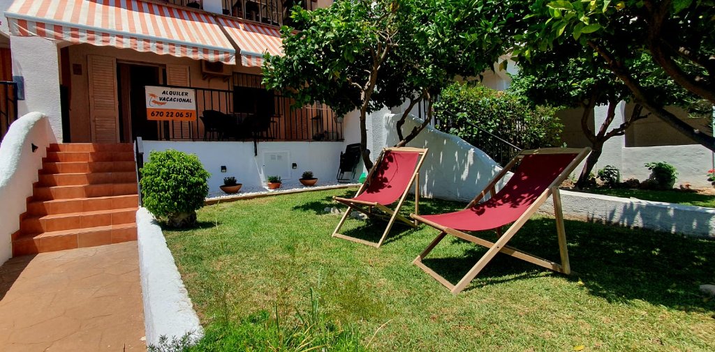 Jardín con tumbonas y árboles
