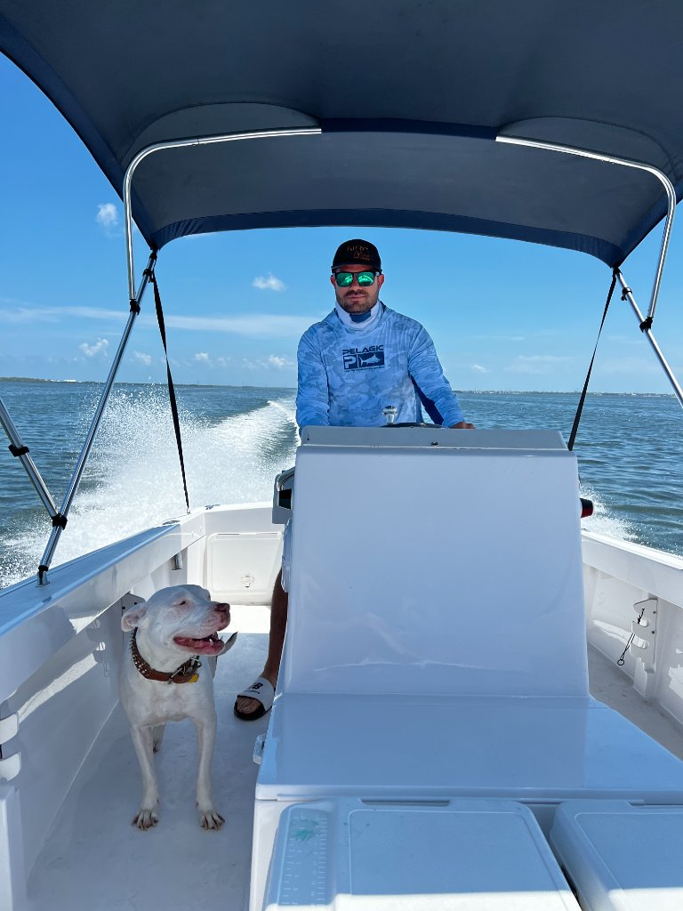 Damian on the water with his dog