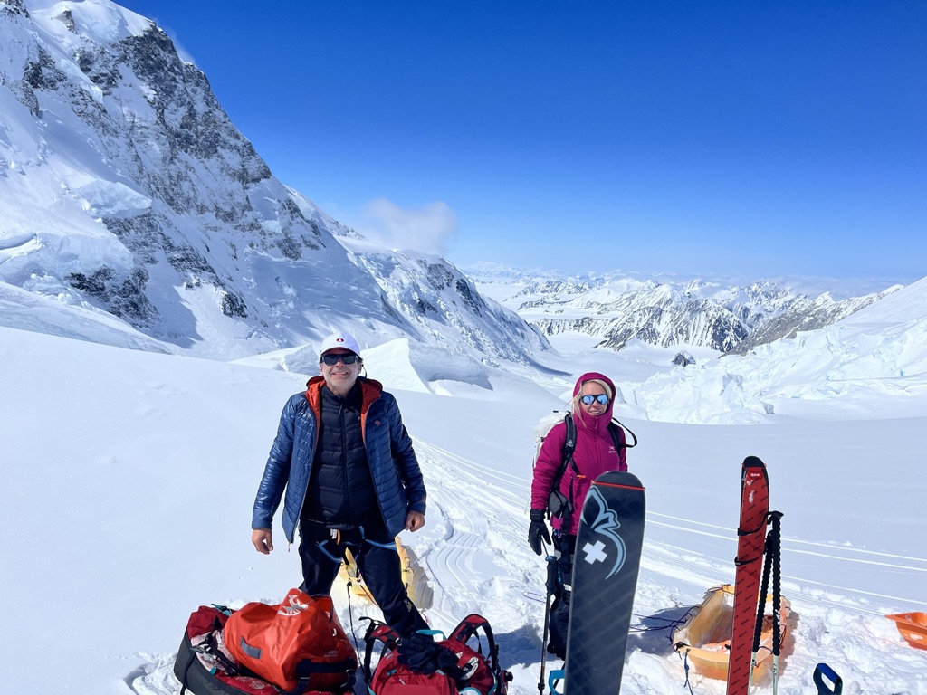 Skiers descending open snowfield above Arctic ocean in Svalbard