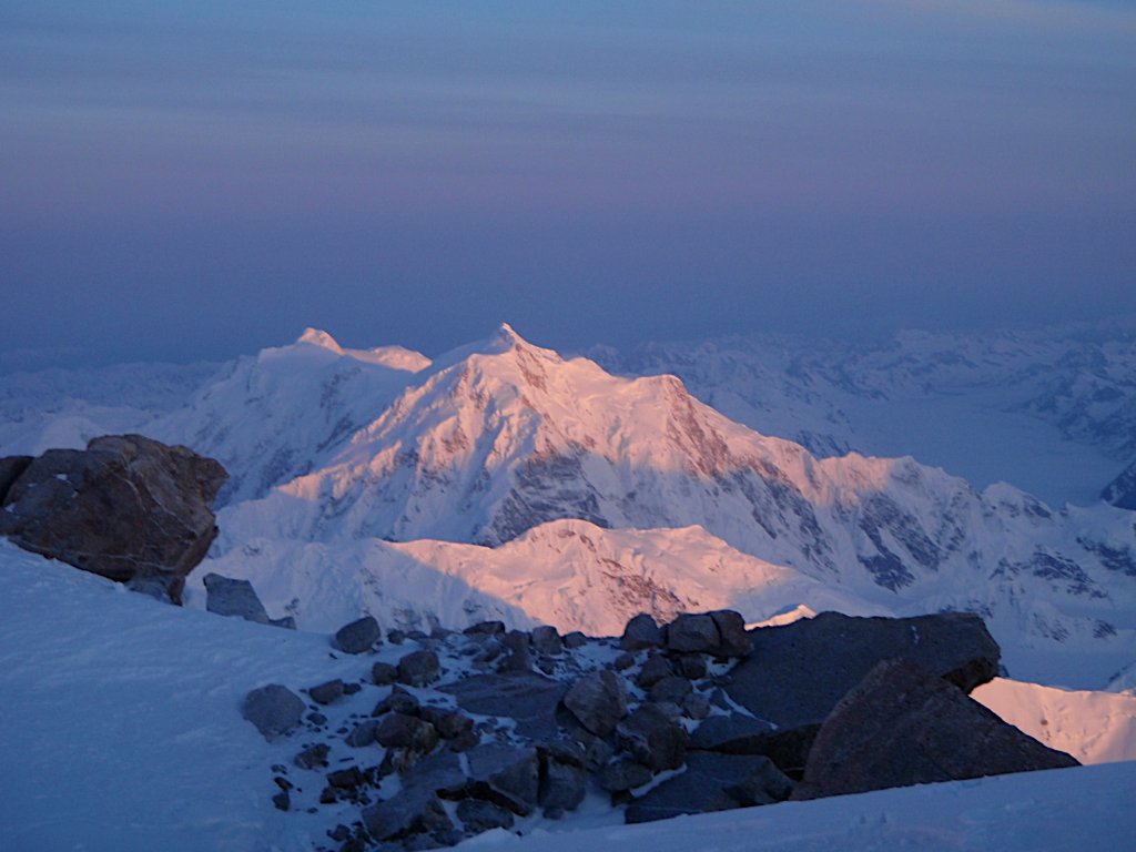 Skiers descending open snowfield above Arctic ocean in Svalbard
