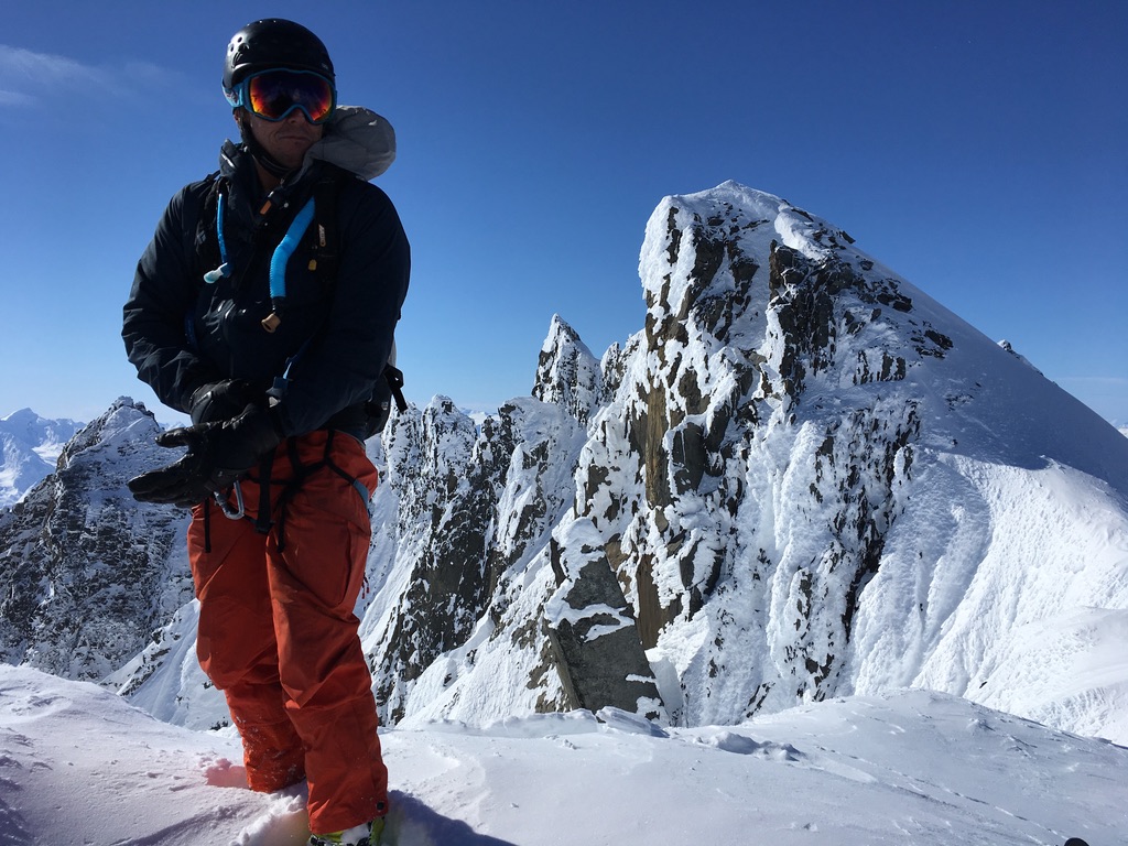 Group skinning up Svalbard ridge with frozen sea ice bay in background