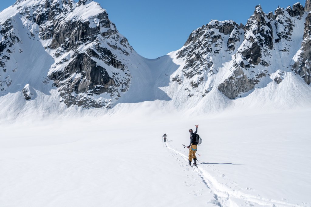 Skier making turns on corn snow with panoramic Arctic landscape, Svalbard