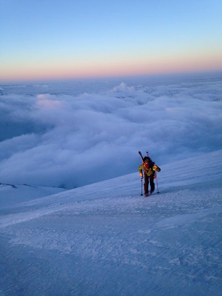 Ski mountaineers ascending steep couloir above Arctic sea in Svalbard, Norway