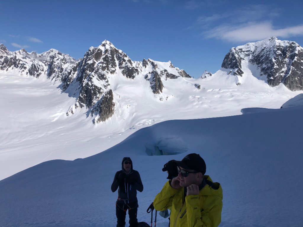 Ski touring group beneath dramatic rock spires in Svalbard Arctic wilderness