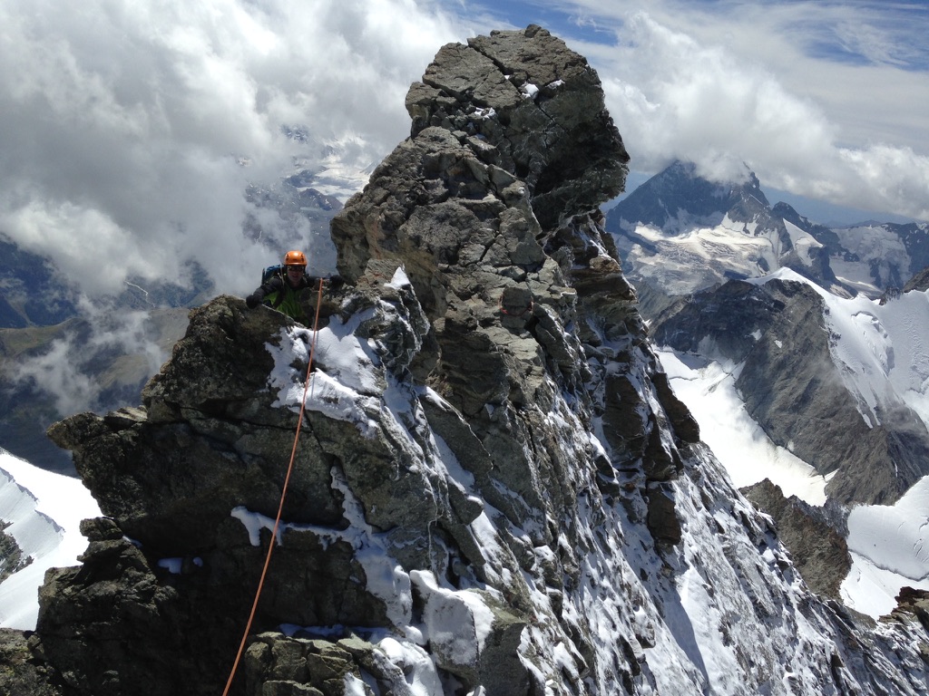 Ski tourers ascending glaciated terrain toward Svalbard summit with sea views