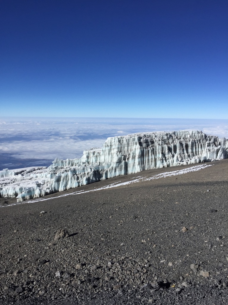 Ski tourers ascending glaciated terrain toward Svalbard summit with sea views