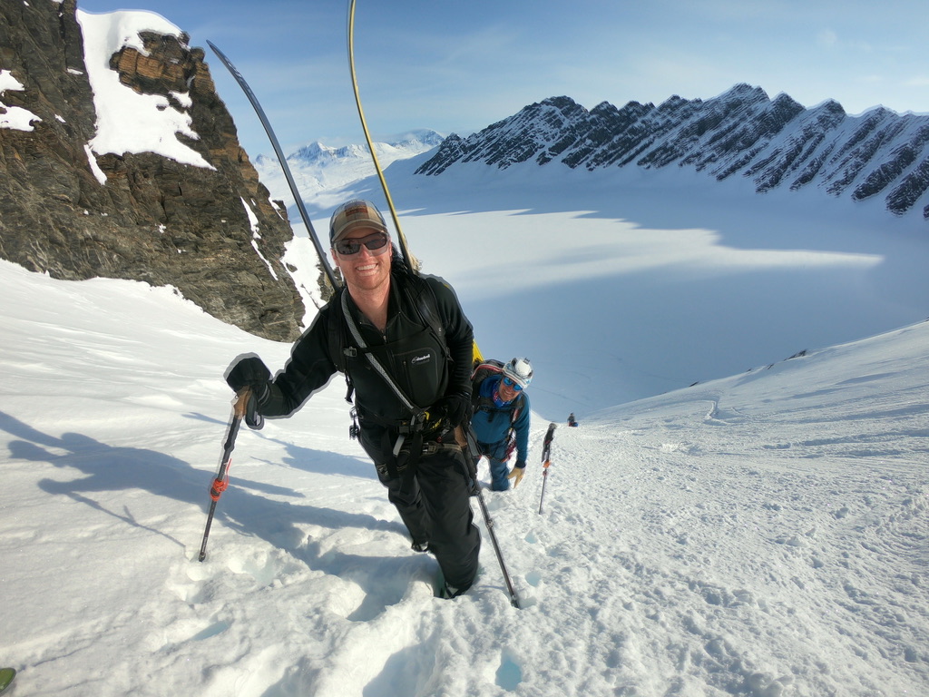 Ski touring group beneath dramatic rock spires in Svalbard Arctic wilderness