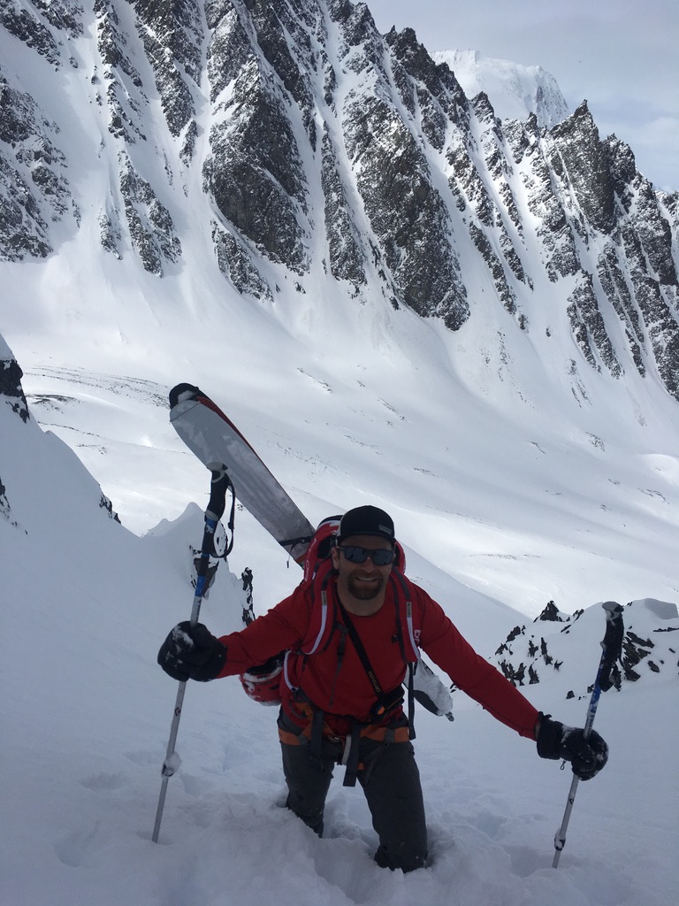 Group of skiers skinning above Arctic fjord on Valdez Alaska Ski Mountaineering + Heli Skiing expedition, Svalbard Norway
