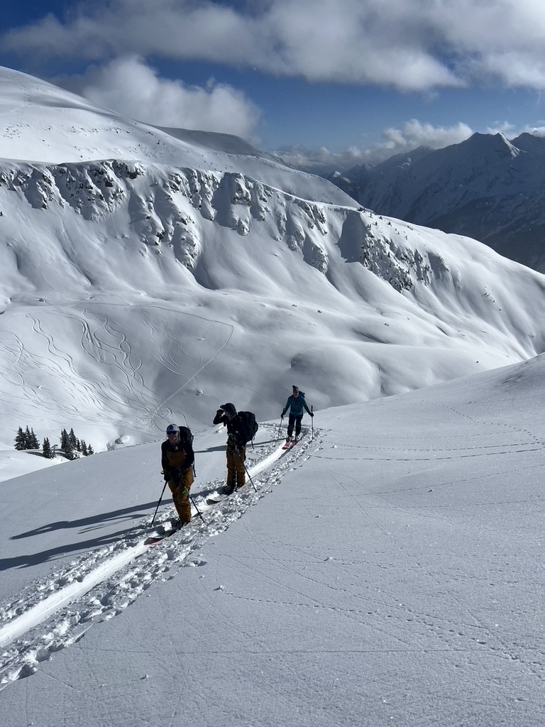 Ski mountaineers ascending steep couloir above Arctic sea in Svalbard, Norway