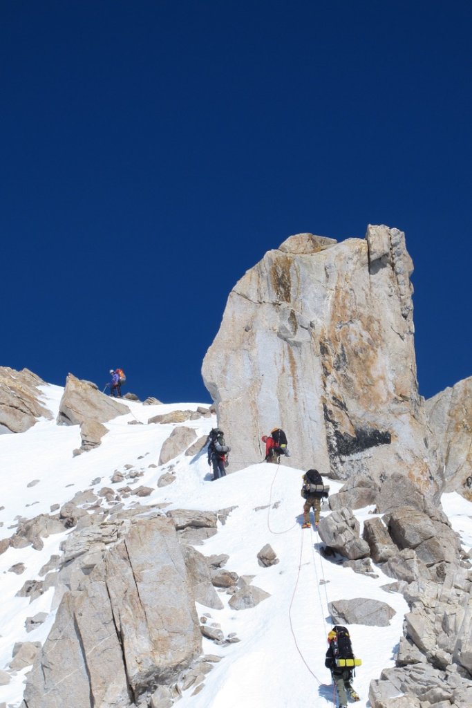 Ski touring group beneath dramatic rock spires in Svalbard Arctic wilderness