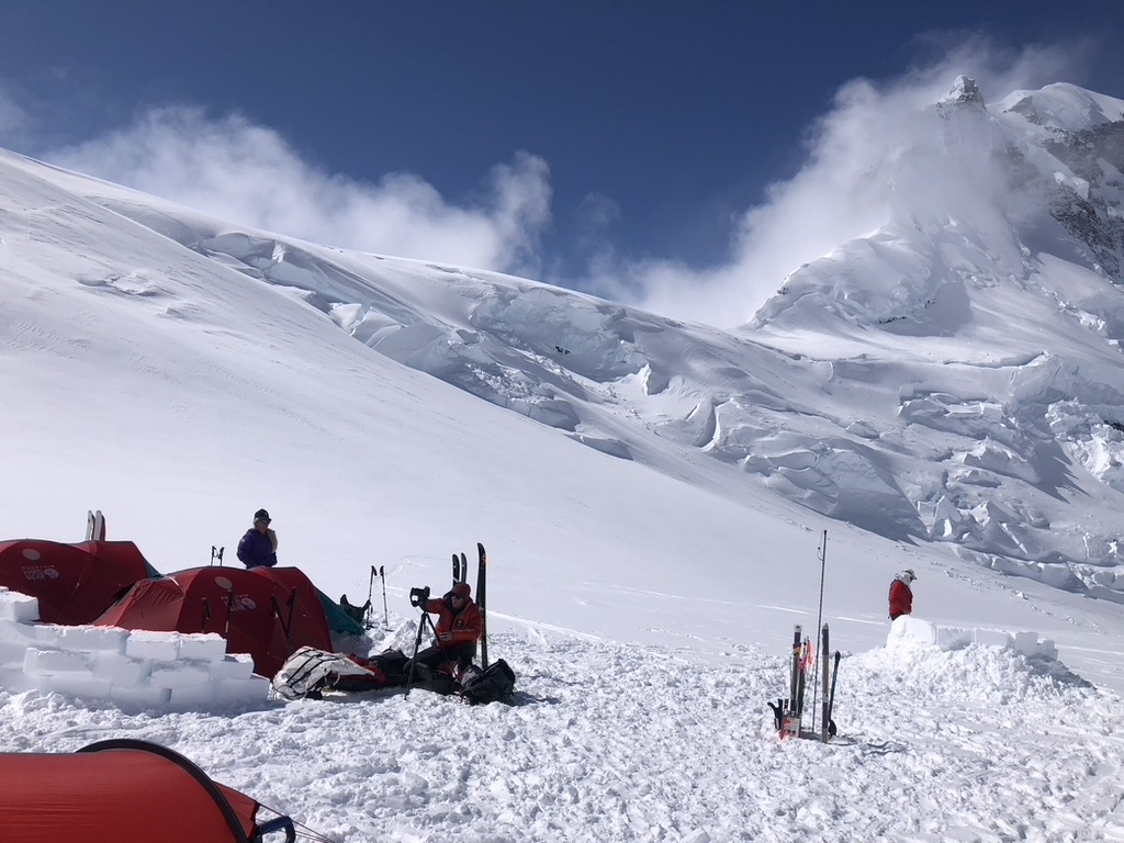 Skier making turns on corn snow with panoramic Arctic landscape, Svalbard