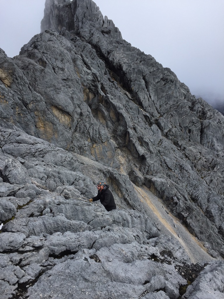 Ski touring group beneath dramatic rock spires in Svalbard Arctic wilderness