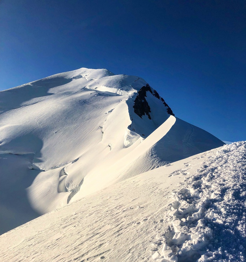 Ski touring group beneath dramatic rock spires in Svalbard Arctic wilderness