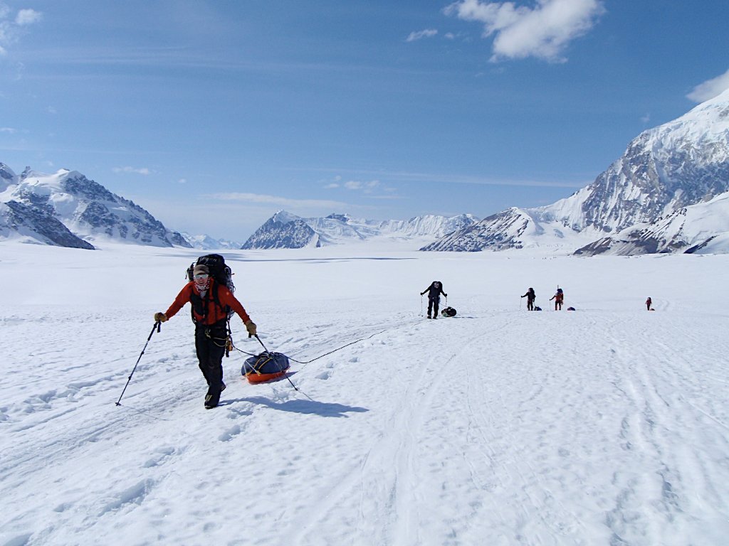 Skier on Arctic glacier with dramatic Svalbard peak and sea horizon