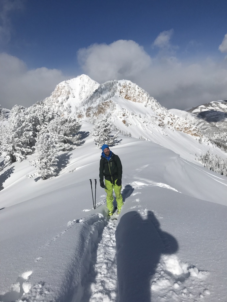 Ski tourers ascending glaciated terrain toward Svalbard summit with sea views