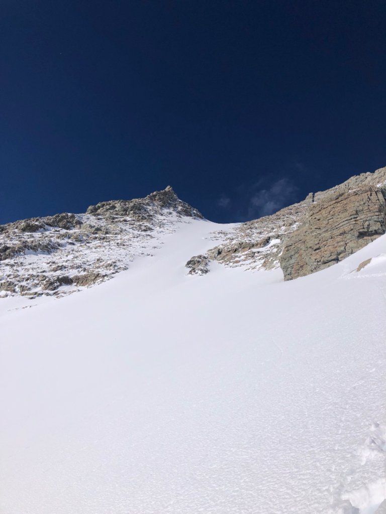 Group of skiers skinning above Arctic fjord on Mt. Tyree, Antarctica expedition, Svalbard Norway