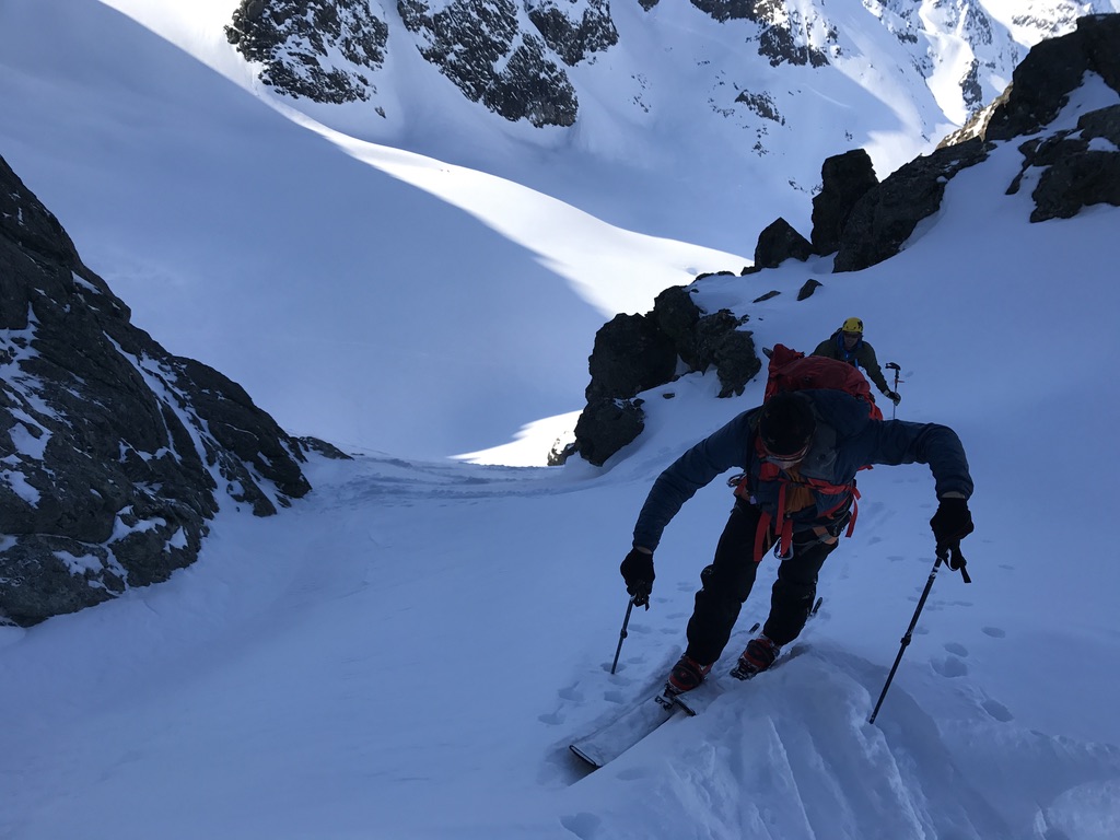 Backcountry skiers navigating narrow snowy gully in Lyngen Alps, Arctic Norway
