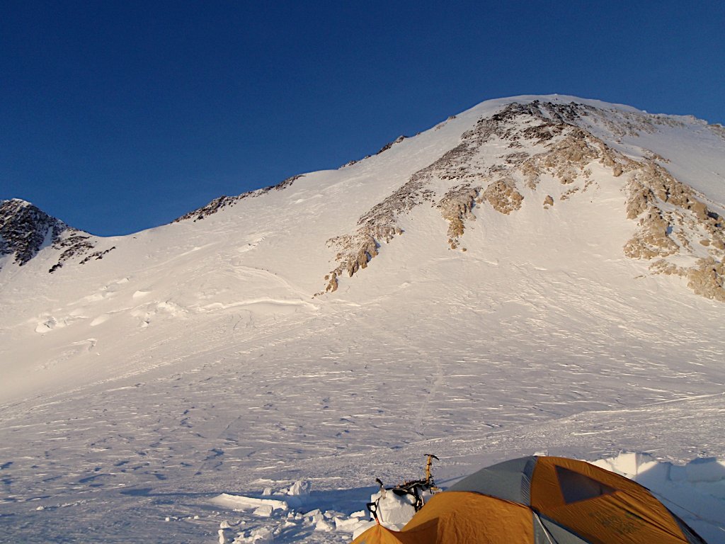 Skier making turns on corn snow with panoramic Arctic landscape, Svalbard