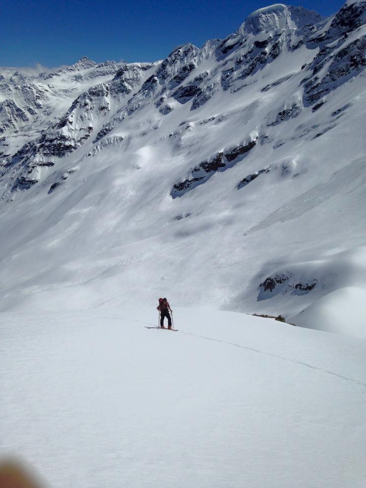 Ski tourers ascending glaciated terrain toward Svalbard summit with sea views