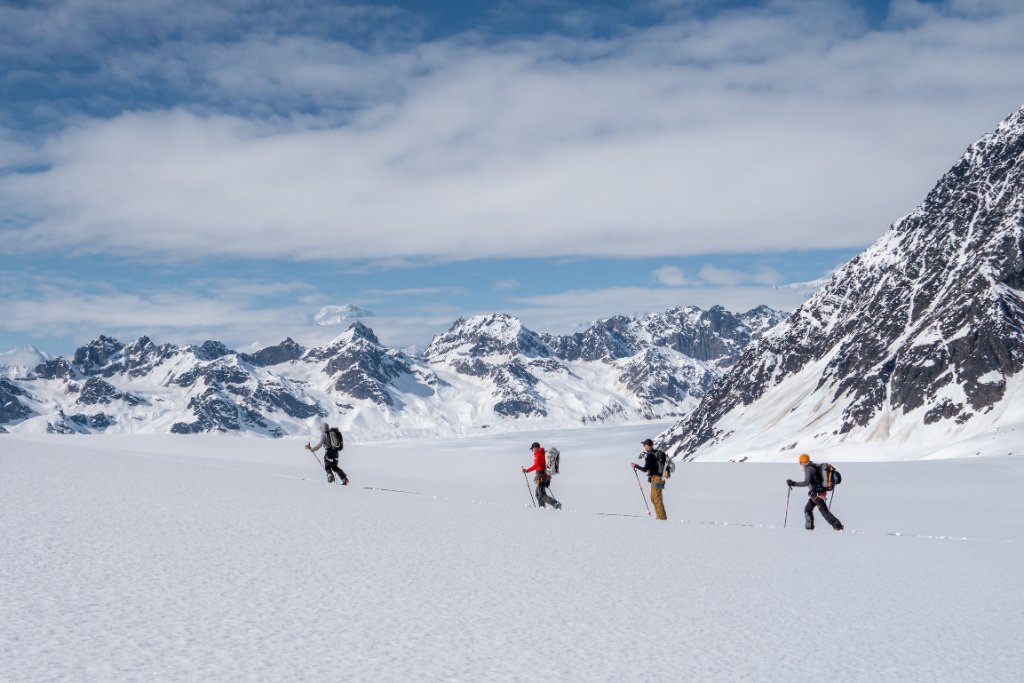 Guides and clients at remote Svalbard ridgeline above frozen Arctic fjord