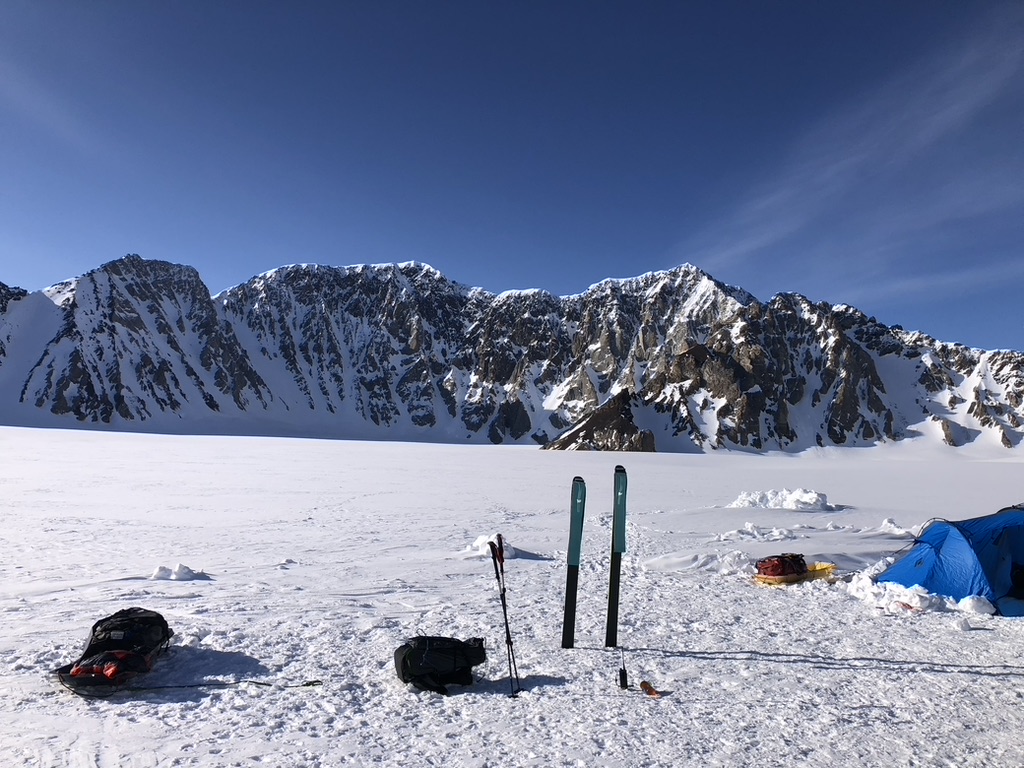 Ski tourers ascending glaciated terrain toward Svalbard summit with sea views