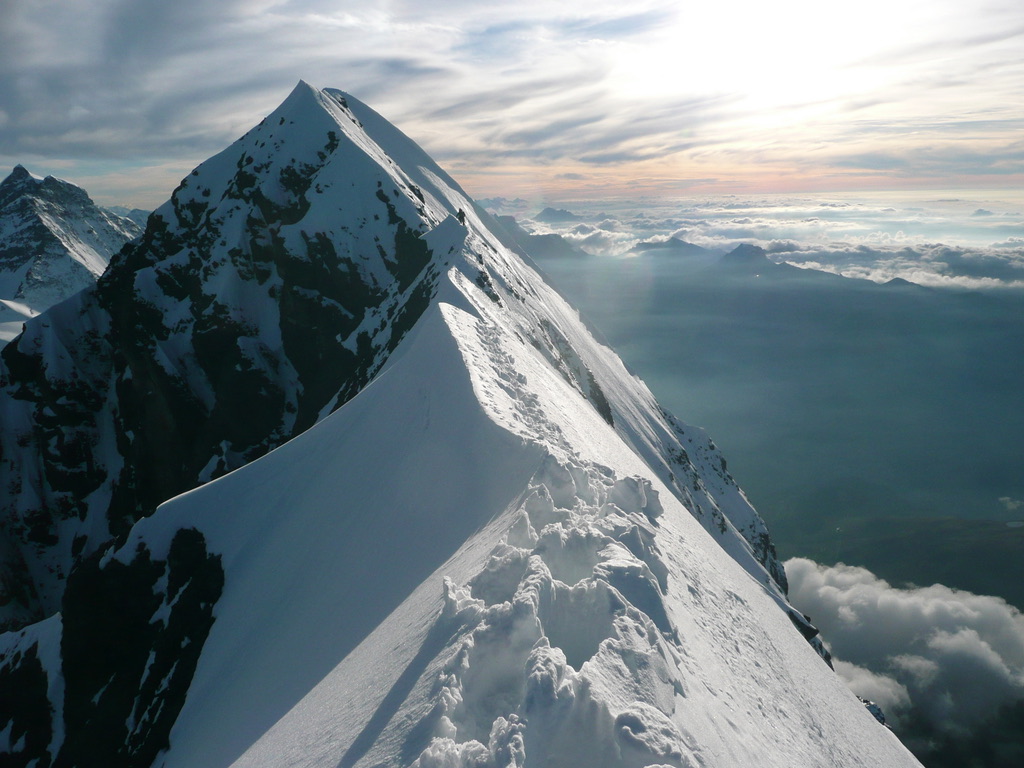 Guides and clients at remote Svalbard ridgeline above frozen Arctic fjord