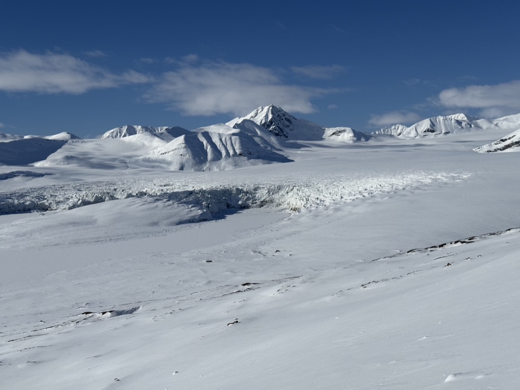 Guides and clients at remote Svalbard ridgeline above frozen Arctic fjord