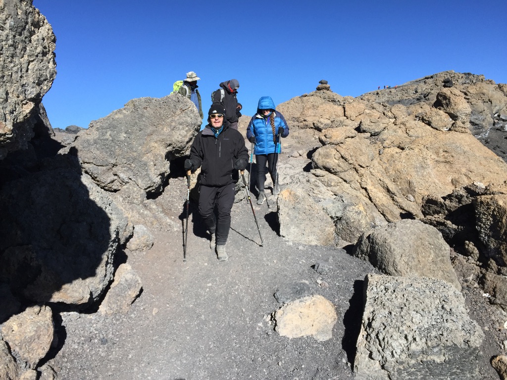 Sea-to-ski group skinning up Svalbard peak with icy fjord and glaciers below