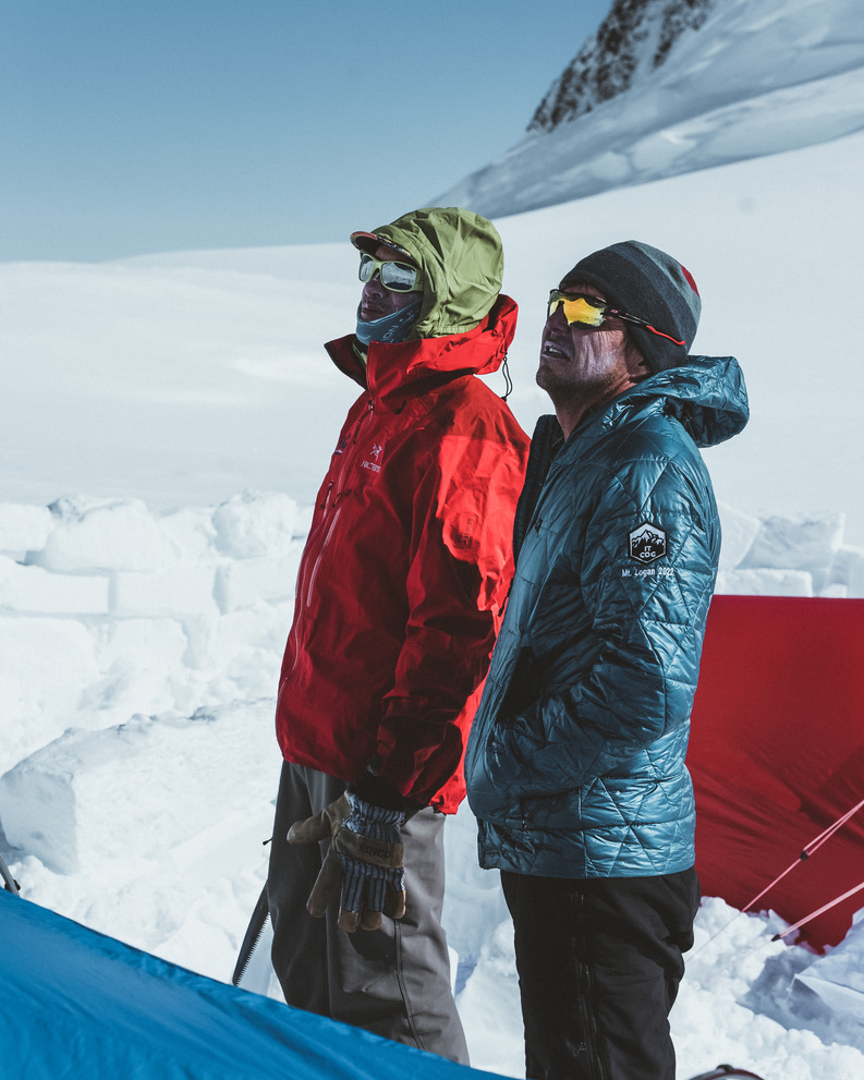 Guides and clients at remote Svalbard ridgeline above frozen Arctic fjord