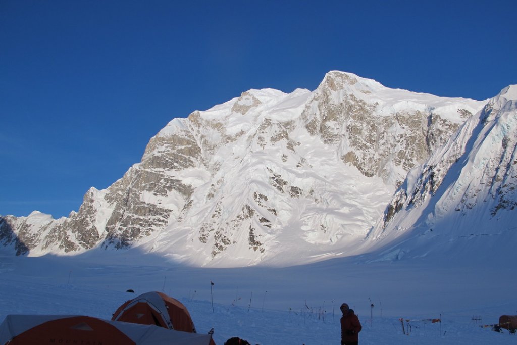 Ski mountaineers ascending steep couloir above Arctic sea in Svalbard, Norway