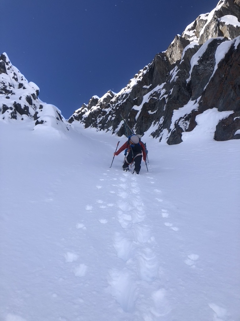 Skiers descending open snowfield above Arctic ocean in Svalbard