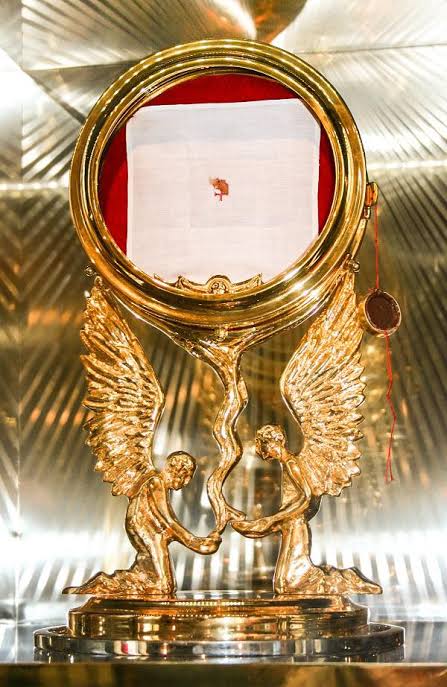 The Sokółka relic enshrined in a gold monstrance, bearing the blood-stained corporal.