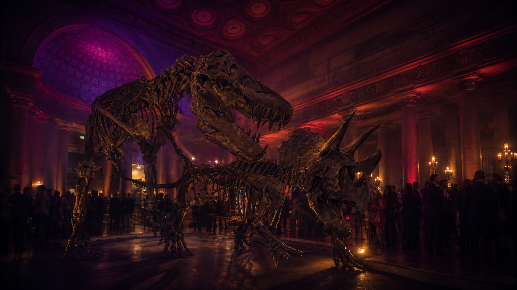 Experiential brand activation inside a grand neoclassical museum hall, a towering T-Rex and Triceratops skeleton exhibit lit by dramatic violet and crimson theatrical lighting, with a silhouetted crowd of guests socializing below the domed ceiling. Live Pros experiential marketing and brand activation production.