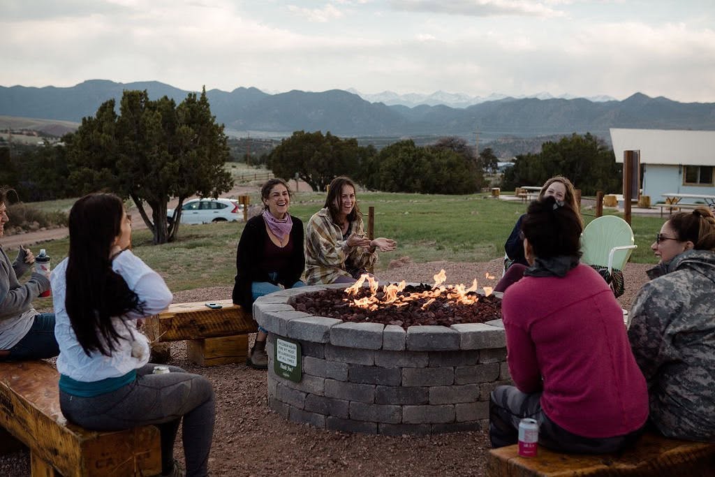 Women gathered around a fire at dusk