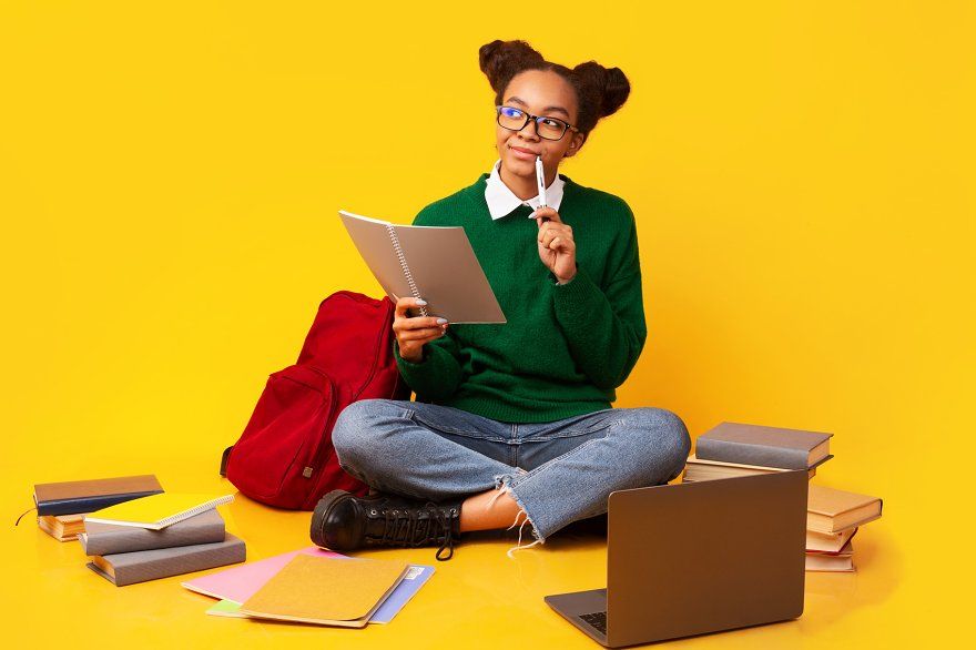 Student studying with books and laptop