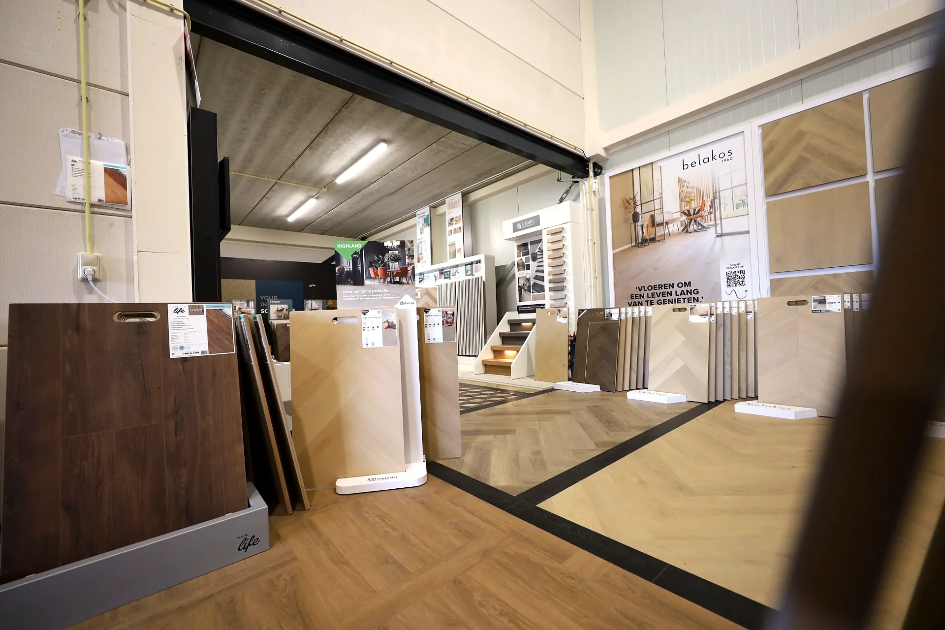 Entree van de showroom met vloerstalen en Belakos wand
