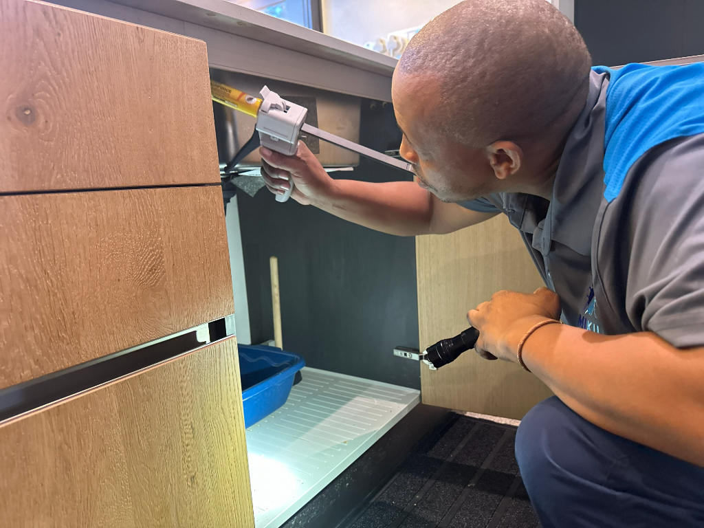 Mikil pest control technician treating for cockroaches in a residential kitchen