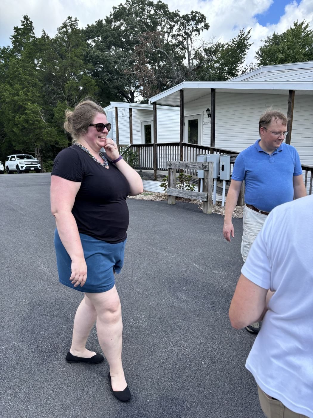 Adults share a laugh in the parking lot during Rally Day