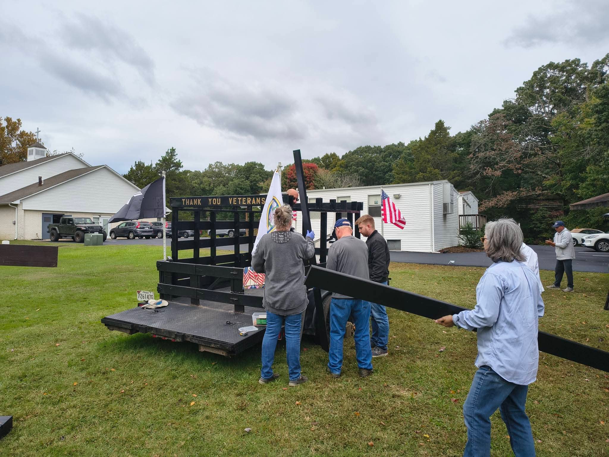 Volunteers carry freshly painted boards to the trailer