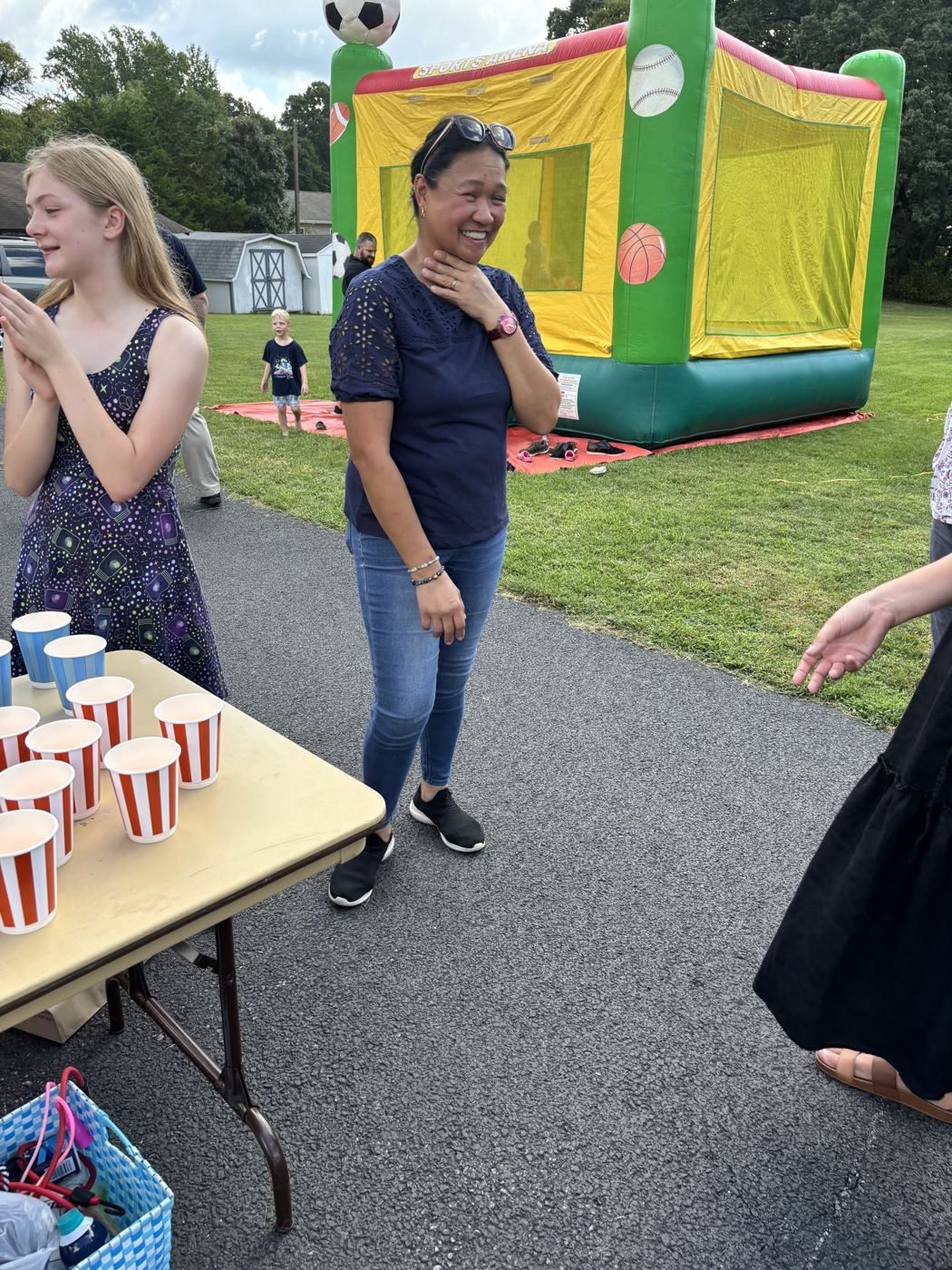 Game table with rows of cups and the bounce house in the background