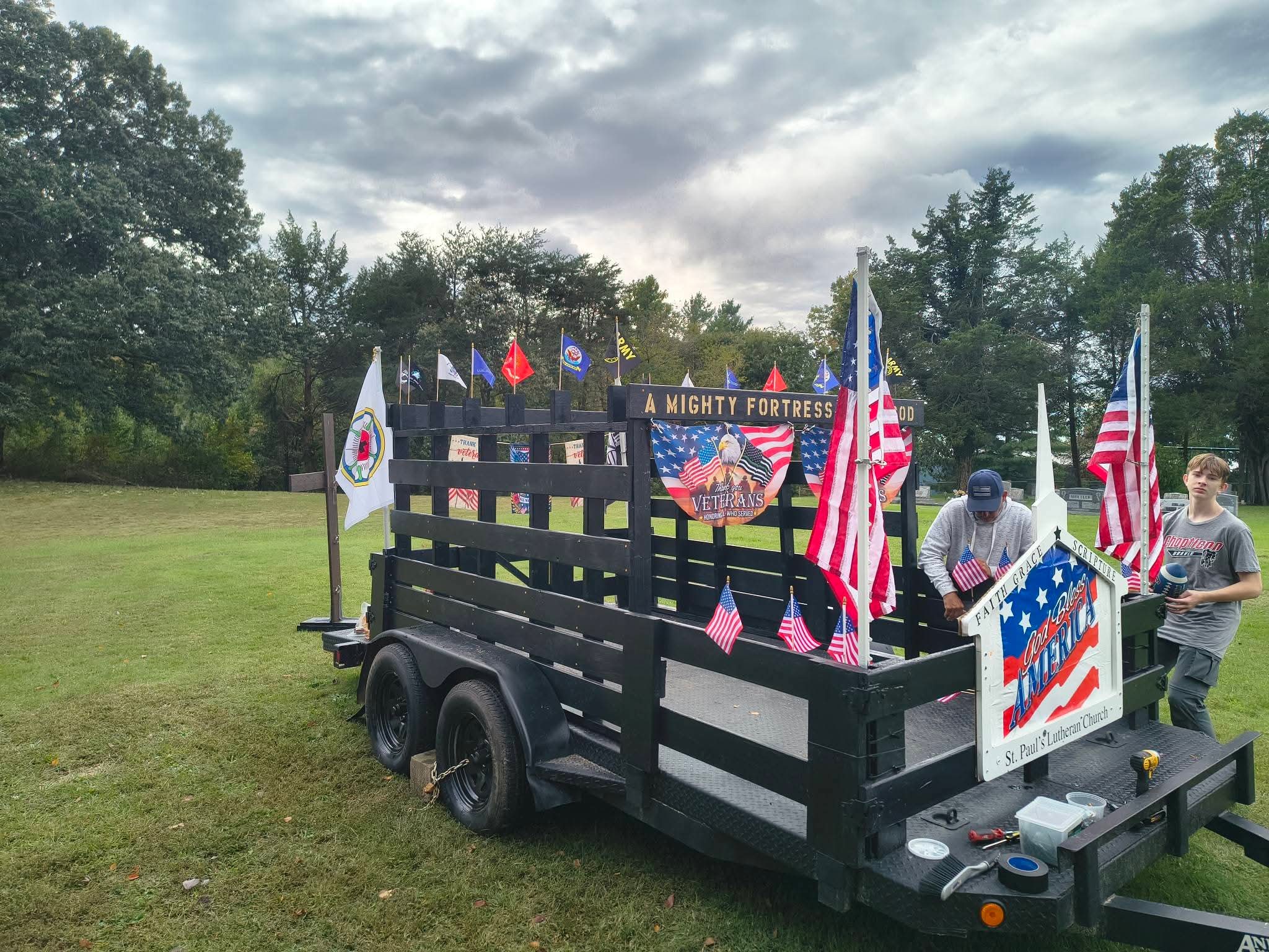 The float with military branch flags lined up along the top rail