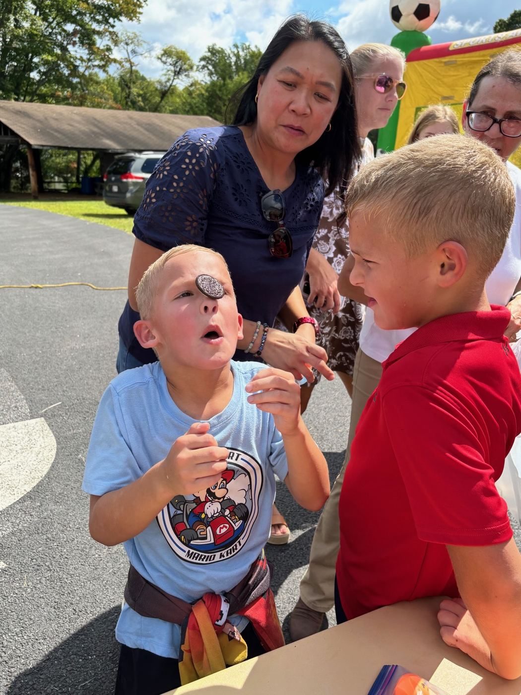 Boy looks up at the Oreo balanced on his forehead