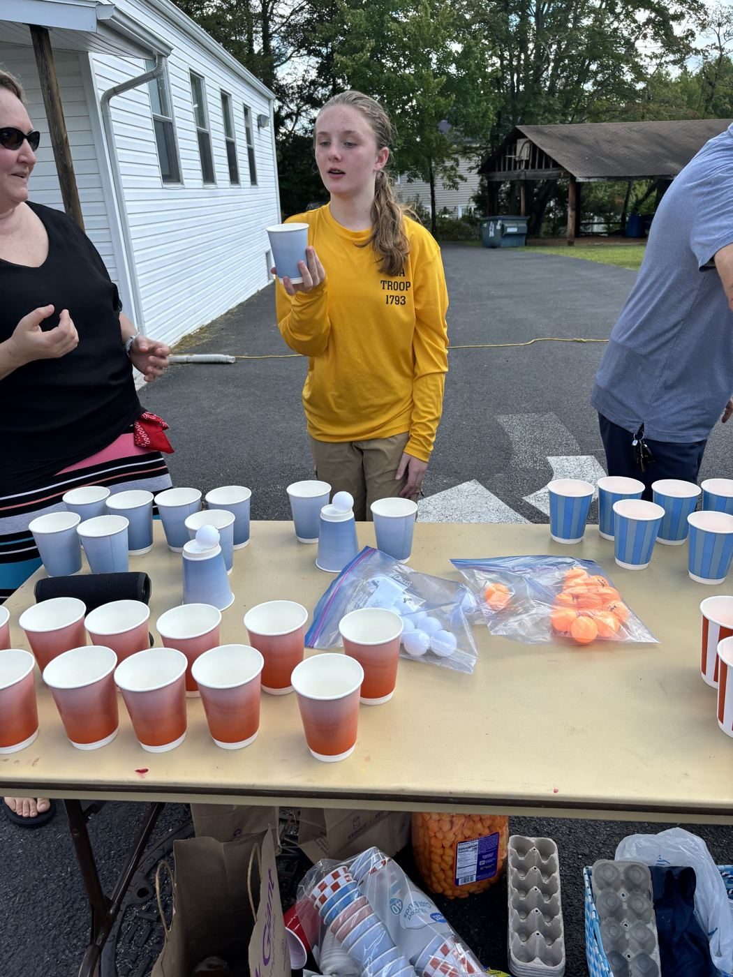 Scout from Troop 1793 runs the cup-and-ball game table
