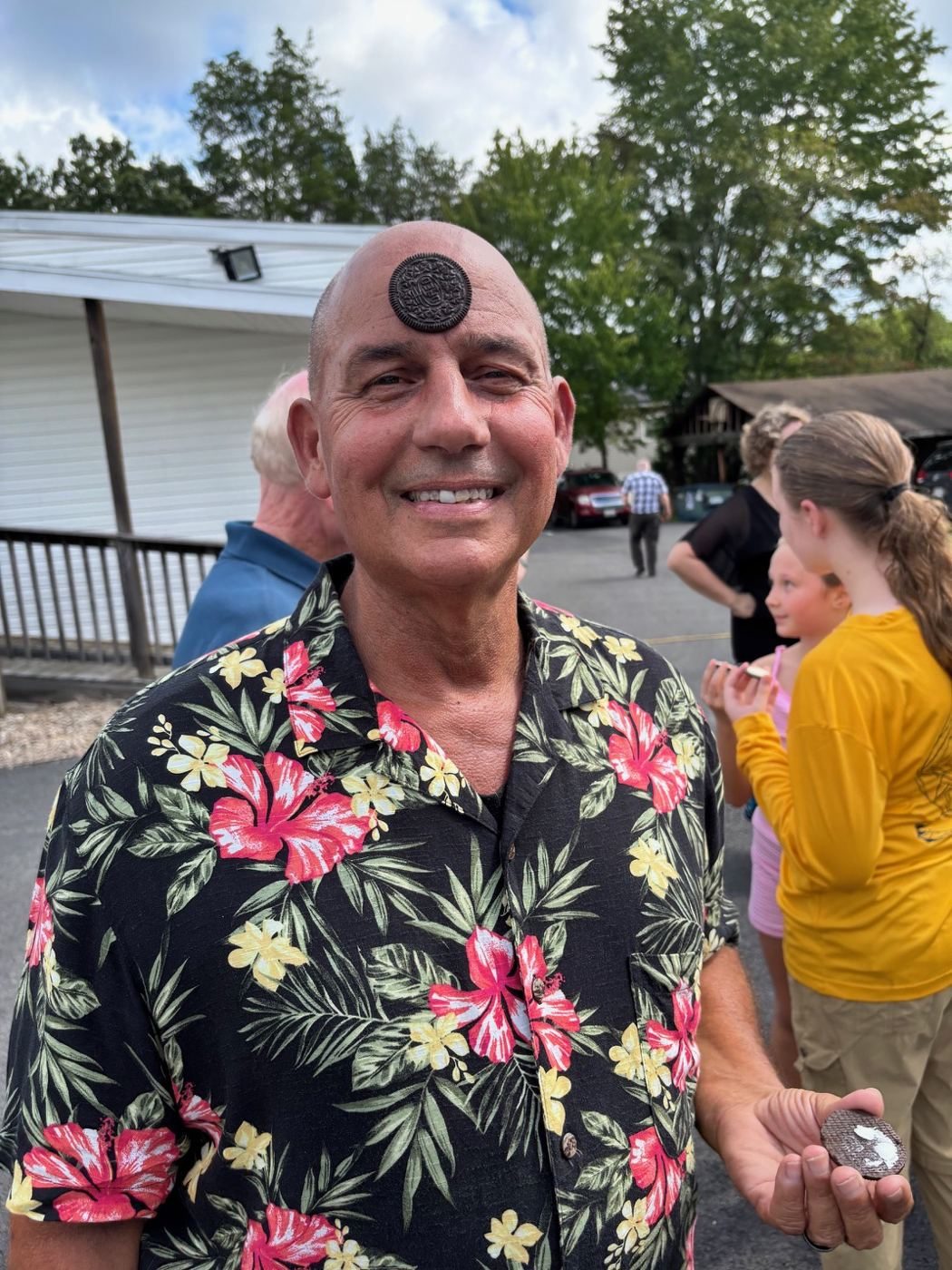 Man smiling with an Oreo balanced flat on his forehead